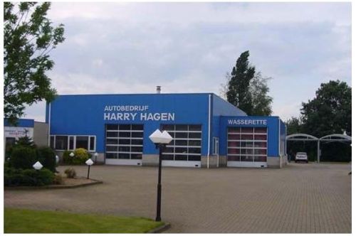 De werkplaats met roldeuren en de naam Autobedrijf Harry Hagen op de gevel